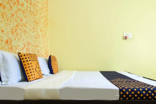 una camera da letto con un letto con cuscini arancioni e neri di SPOT ON Saini Guest House a Roorkee