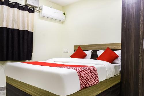 a bedroom with a large bed with red pillows at Flagship S&h Residency in Khandagiri