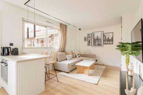 un salon blanc avec un canapé et une table dans l'établissement Luxurious 3 min walk from Eiffel Tower, à Paris