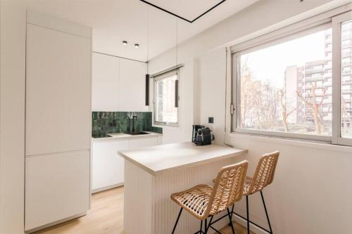 une cuisine avec deux chaises, un comptoir et une fenêtre dans l'établissement Luxurious 3 min walk from Eiffel Tower, à Paris