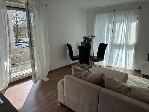 salon z kanapą i stołem w obiekcie Exklusives Apartment für 5 Personen in der Nähe von Frankfurt w mieście Hanau