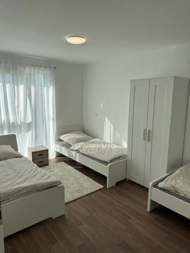 sypialnia z 3 łóżkami i białą szafką w obiekcie Exklusives Apartment für 5 Personen in der Nähe von Frankfurt w mieście Hanau