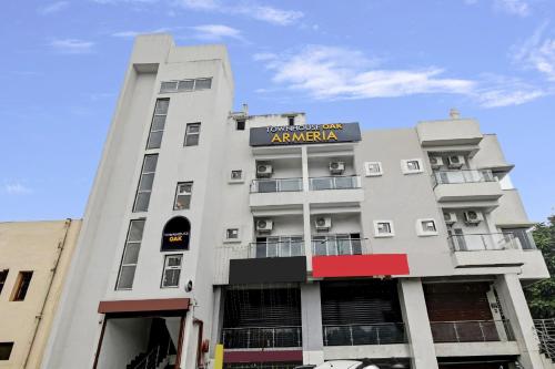 a white building with a sign on it at Super Townhouse OAK Armeria in Lucknow