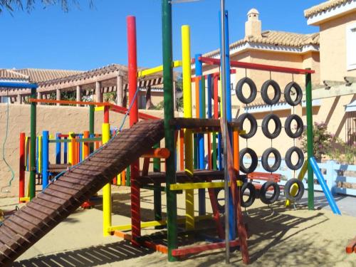 House sleeps 6, large pool walk to beach في فيرا: ملعب ملونة مع زحليقة في الحديقة