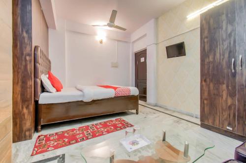 OYO Flagship 78696 Hotel Kamini في باتنا: غرفة نوم بسرير وطاولة زجاجية