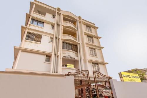 un edificio blanco alto con una puerta delante en OYO Flagship 78696 Hotel Kamini en Patna