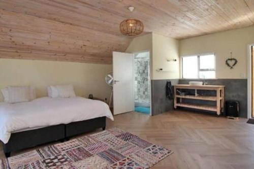 una camera con un grande letto e un soffitto in legno di Studio firlands a Sir Lowry Pass