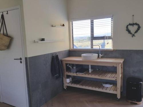 un piccolo bagno con lavandino e finestra di Studio firlands a Sir Lowry Pass