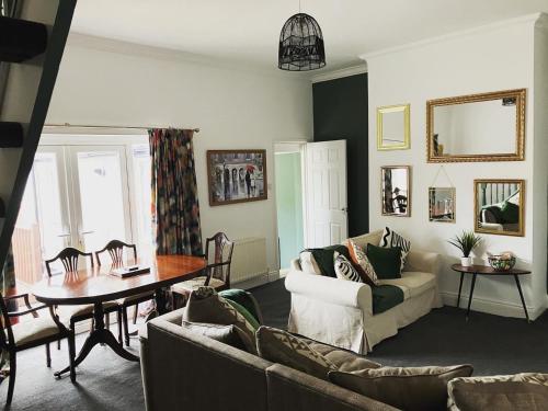 a living room with a couch and a table at Rose Cottage - City Centre, Hospital CrownWork Studios, Nissan & Stadium of Light in Sunderland