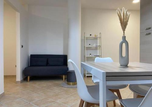 a dining room with a table and a blue couch at [Loft Comodo ed Elegante] • Wi-Fi e Colazione in Sanluri