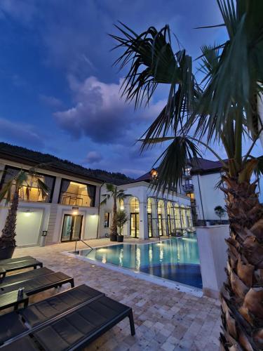 a villa with a swimming pool at night at RIVER Hotel & SPA in Călimăneşti