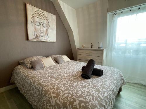 a bedroom with a large bed with a large window at Appart Cosy 2 chambres in Bruz
