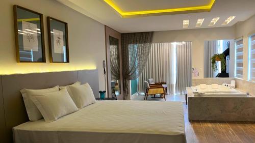 a bedroom with a large bed and a bathroom at Resort Ecoar in Gaspar