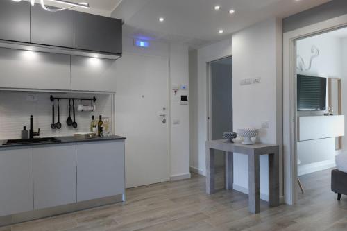 a kitchen with white cabinets and a table in a room at Regina's home in Bari