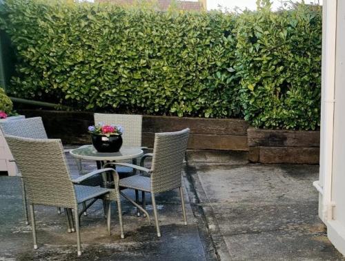 a table with chairs and a vase of flowers on it at Russell Mews in Ennis