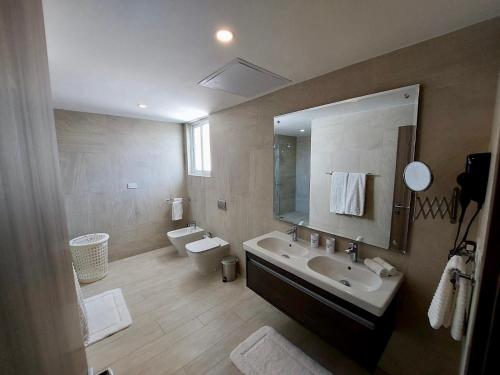 een badkamer met een wastafel, een toilet en een spiegel bij Unique lake, Golf & Jacuzzi in Hard Rock Golf PC in Punta Cana