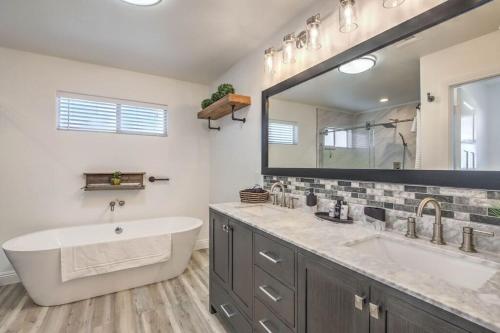 uma casa de banho com um lavatório e um espelho grande em Chateau Desert Oasis minutes from Vegas Strip em Las Vegas