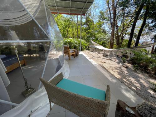 a porch with two chairs and a hammock on it at Amaj Eco Lodge in Sámara