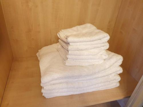 a stack of white towels sitting on a shelf at London Luxury 2 Bedroom Flat Sleeps 8 free parking in East Barnet