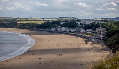 a group of people on a beach near the ocean at Blacksmiths Cottages in Filey