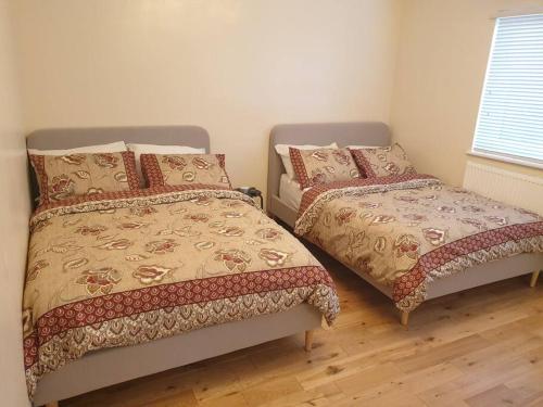 a bedroom with two beds and a window at London Luxury 2 Bedroom Flat Sleeps 8 free parking in East Barnet
