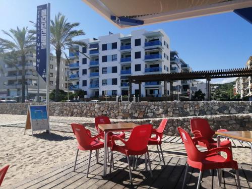 BLAU MARÍ 175 في كالافيل: طاولة وكراسي على شاطئ به مبنى