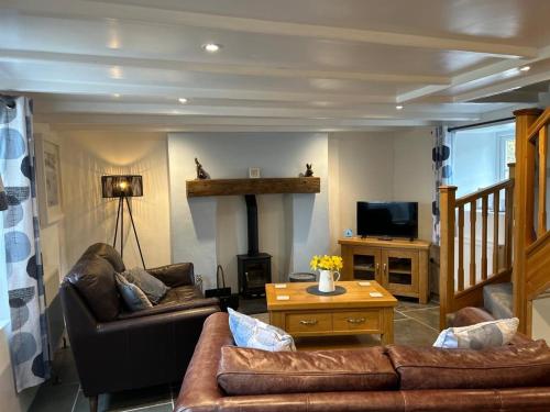 sala de estar con 2 sofás y chimenea en Pendragon, en Penzance