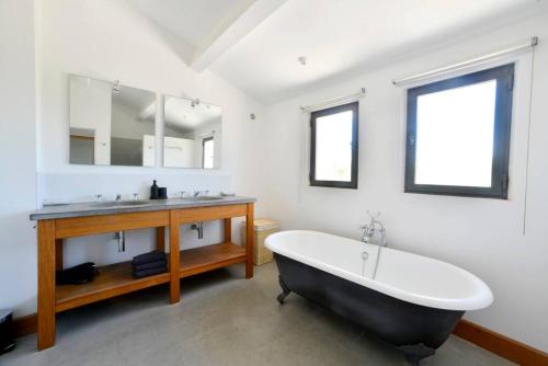 La salle de bains est pourvue d'une baignoire en noir et blanc et d'un lavabo. dans l'établissement Magnifique Villa Uzès avec Piscine, à Uzès
