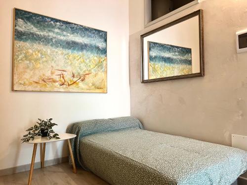 ein Schlafzimmer mit einem Bett und einem Bild an der Wand in der Unterkunft Bilocale Nel Centro Storico - Prossimo al Mare in Pachino
