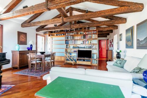 ヴェネツィアにあるLe Mansarde Deluxeの白い家具と木製の天井が備わるリビングルーム