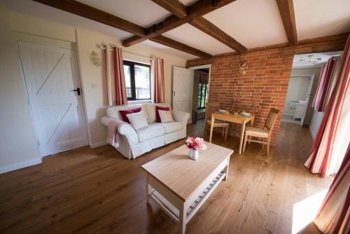 uma sala de estar com um sofá e uma mesa em Rural cottage with swimming pool! em High Halden