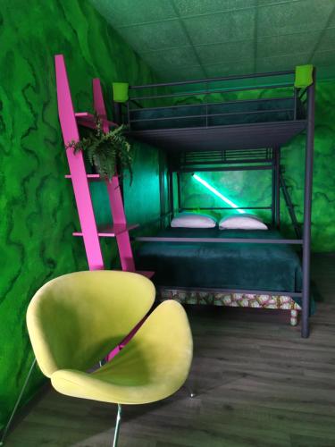 a green room with a yellow chair and a bunk bed at Studio dans le bâtiment industriel de la Micro-Brasserie Radwulf in Vieux-Ferrette