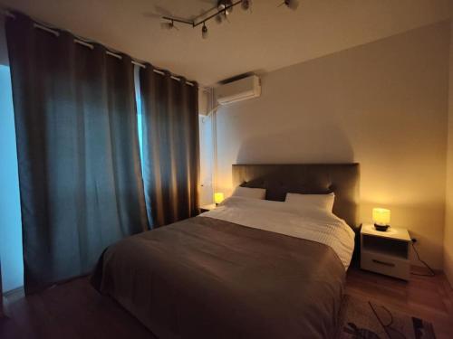 - une chambre avec un lit et deux lampes sur une table dans l'établissement Apartament The Cozy Nest Turda, à Bucarest