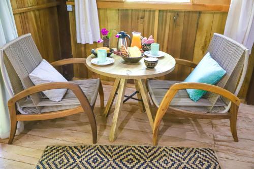 a small table with two chairs and a table with drinks on it at POUSADA BAWARY in São Gabriel da Cachoeira
