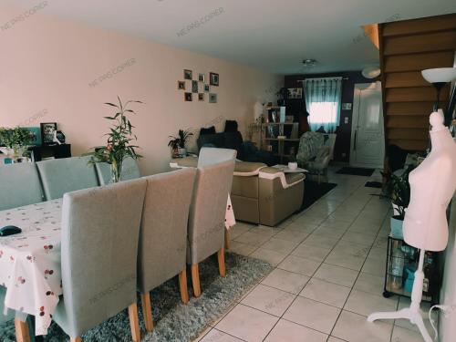 ein Wohnzimmer mit einem Tisch und Stühlen in der Unterkunft Maison au calme a Arnage in Arnage