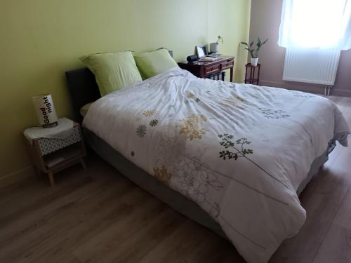 una camera da letto con un grande letto e un piumone bianco di Maison au calme a Arnage ad Arnage