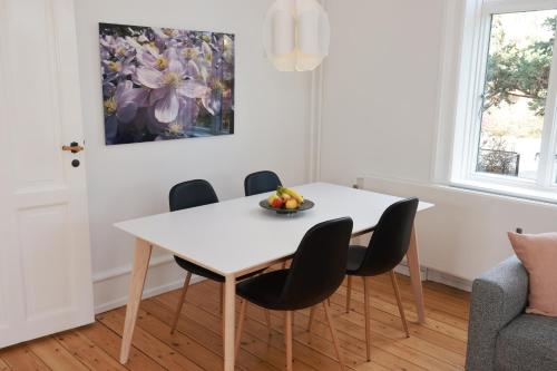 comedor con mesa blanca y sillas en Scandi-Hygge Seaside House - only 10mins to Copenhagen, en Charlottenlund