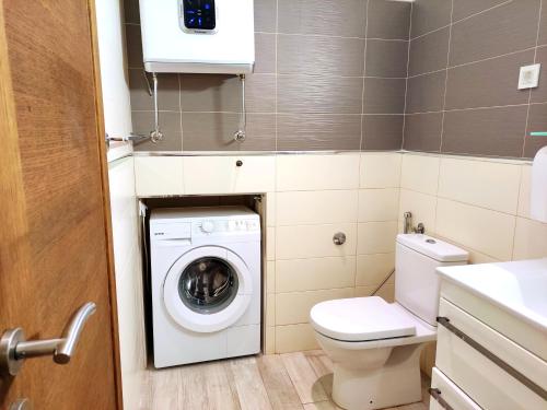 een kleine badkamer met een wasmachine en een toilet bij Skyline View Apt & Pool Retreat in Budva