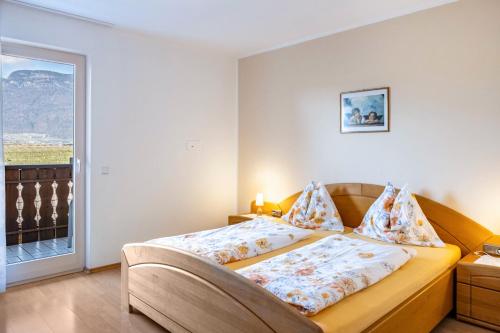 a bedroom with a bed and a large window at Valtlhof - Apt 1 in Cornaiano