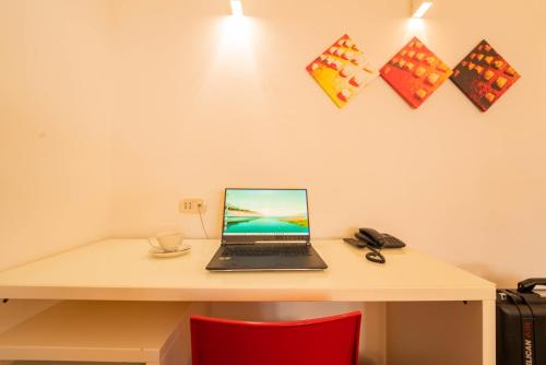 a laptop computer sitting on a desk with a red chair at Slavija Culture Heritage Hotel in Split