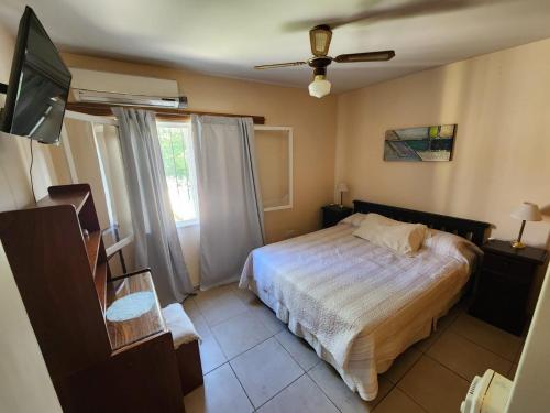a bedroom with a bed and a tv and a window at Casa Barrio Cooperativo Villa Maria in San Juan