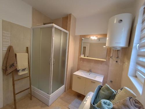uma casa de banho com uma cabina de duche em vidro e um lavatório. em City Center em Labin