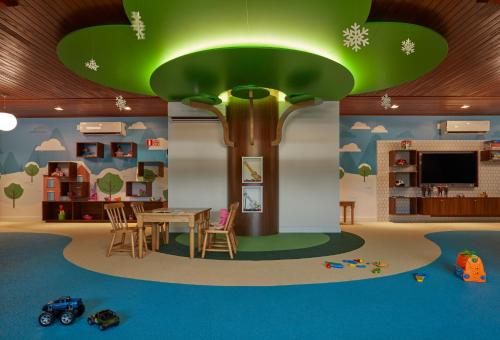 a room with a table and a tree in the middle at Exclusive Gramado Hotel & Spa by Gramado Parks in Gramado