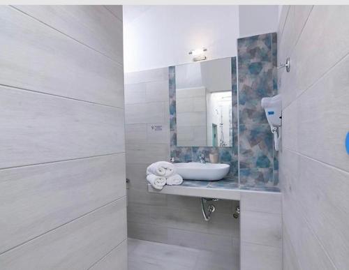 Baño blanco con lavabo y espejo en Lena Apartments 3, en Potos