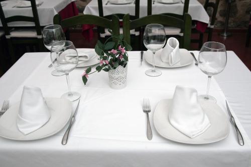 a table with white plates and wine glasses on it at Gran Hostal San Segundo in Avila