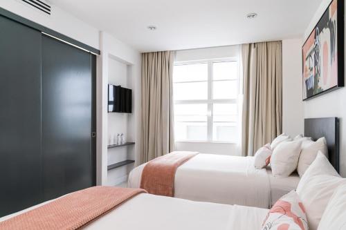 a hotel room with two beds and a window at Clevelander Hotel in Miami Beach