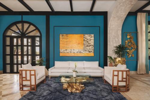 a living room with blue walls and white couches at Sanctuary Cap Cana, a Luxury Collection Resort, Dominican Republic, Adult All-Inclusive in Punta Cana