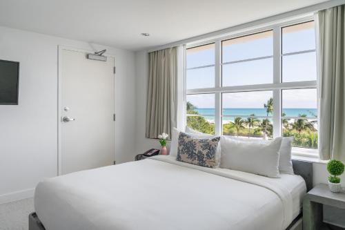 a bedroom with a large white bed and a large window at Clevelander Hotel in Miami Beach