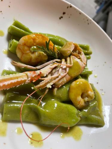 a white plate of food with shrimp and vegetables at Kingfish restaurant & boutique hotel in Patog