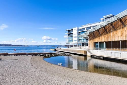 a building on a beach next to a body of water at Tjuvholmen / Aker Brygge - Most expensive area in Oslo! in Oslo
